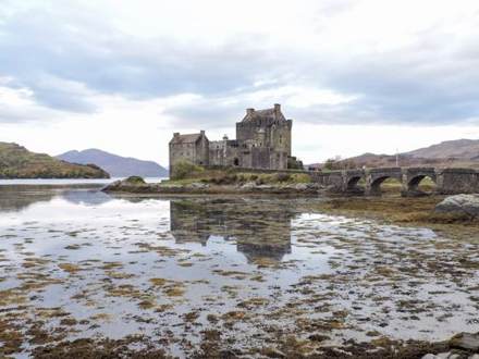 Eilean Donan Castle reflected in the water, with its stone bridge
